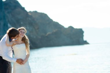 Romantik Çift sahilde eğleniyor. Sevgi, çekici bir adam ve kadının akşam gün batımını izlemek, tutuşup genç