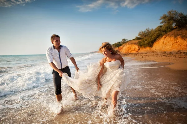 Romantik Çift sahilde eğleniyor. Sevgi, çekici bir adam ve kadının akşam gün batımını izlemek, tutuşup genç — Stok fotoğraf