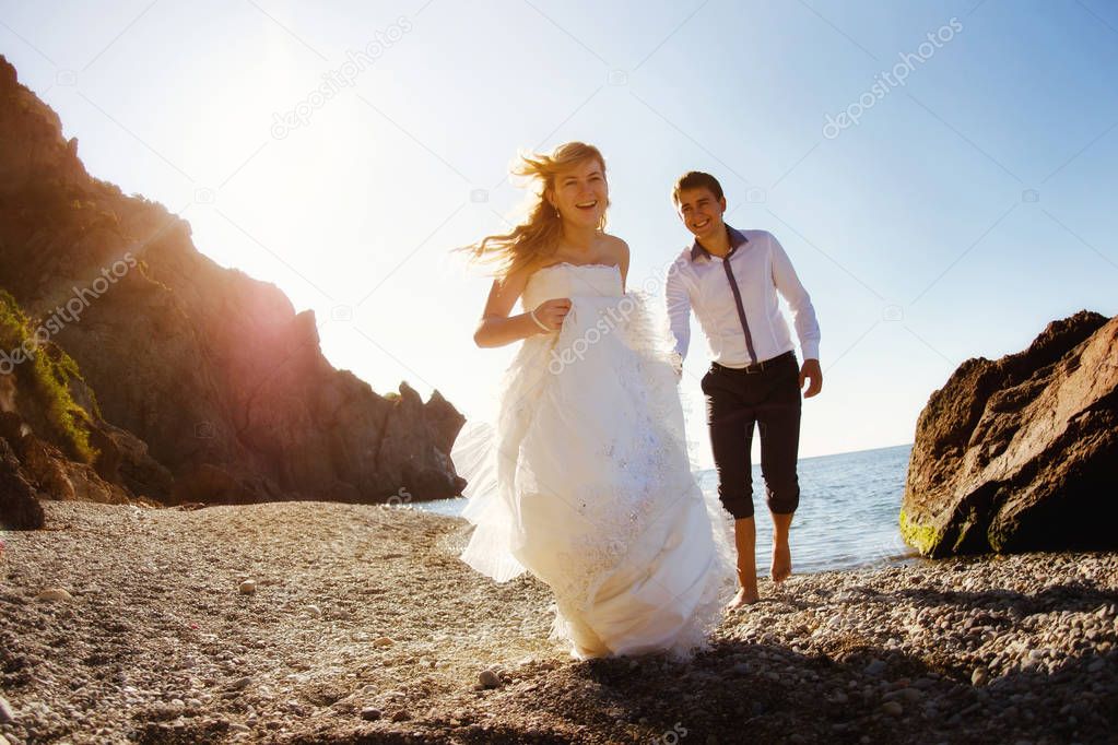 Romantic couple having fun on the beach. Young  in love, Attractive man and woman enjoying  evening  the , Holding hands watching the sunset