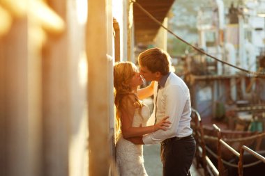 Mutlu gelin ve damat bir yatta sarılma - her otherevening arıyorsunuz güneş sarı