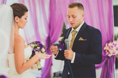 Lüks açık hava düğün töreni Okyanusu yakınlarındaki haze çadırda üzerinde şık mutlu gülümseyen yeni evliler