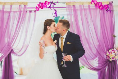 Lüks açık hava düğün töreni Okyanusu yakınlarındaki haze çadırda üzerinde şık mutlu gülümseyen yeni evliler