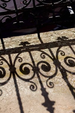 Balkonda tarihi rustik korkuluklar güzel gölgeler oluşturuyor.