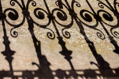 Balkonda tarihi rustik korkuluklar güzel gölgeler oluşturuyor.