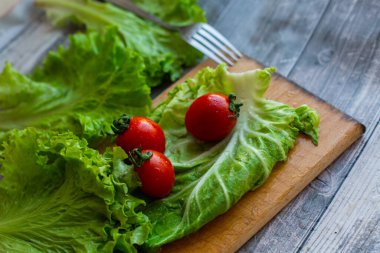 Kesme tahtasında lahana ve salata olan domatesler.