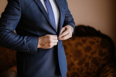 Adam mavi ceketini bağlıyor.