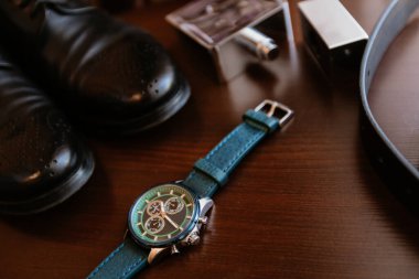 Erkeklerin özellikleri - saatler, ayakkabılar, kemer, parfüm, masanın üstünde yatan