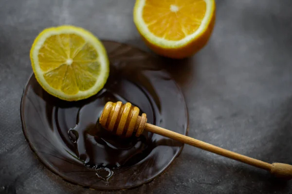 black tea with honey, lemon on a gray background