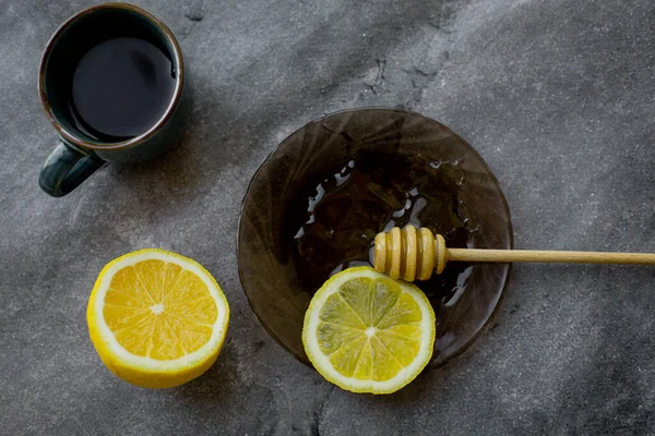 wooden spoon of honey with lemon and black tea