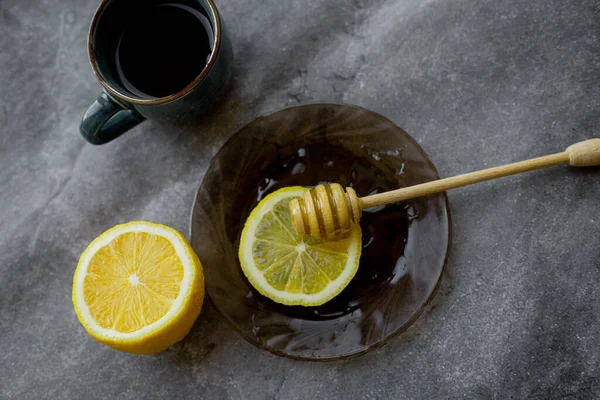 wooden spoon of honey with lemon and black tea