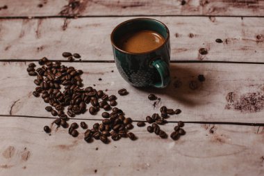 Kahveli kahve, kahve çekirdeği ve ahşap bir masa.