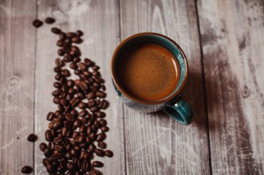 Kahveli kahve, kahve çekirdeği ve ahşap bir masa.