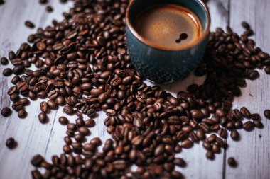 Kahveli kahve, kahve çekirdeği ve ahşap bir masa.