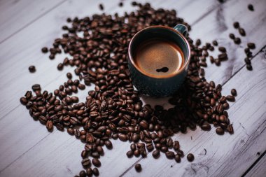 Kahveli kahve, kahve çekirdeği ve ahşap bir masa.