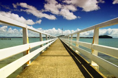 İskele ve mavi gökyüzü arka plan görünümünü kapatın. Denizin ortasında yayalar için köprü.