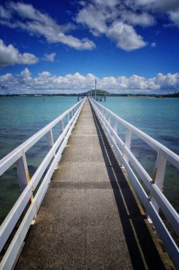 İskele ve mavi gökyüzü arka plan görünümünü kapatın. Denizin ortasında yayalar için köprü.