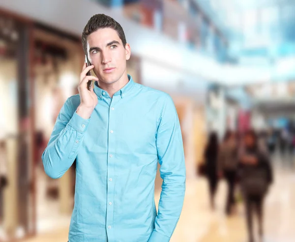 Close up of a doubtful young man using a cellphone