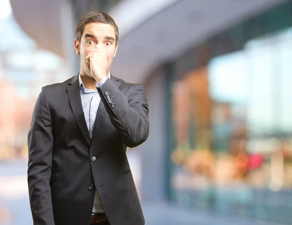 Concerned businessman covering his nose