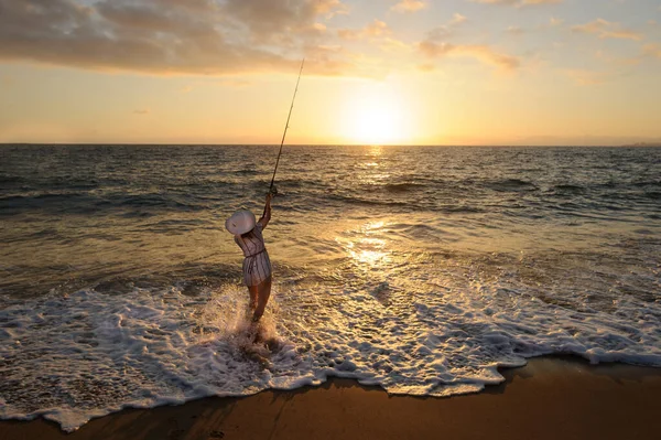 Ocean Fishing Casting is a Woman Cast Fishing on the Beach at Sunset