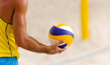A Male Beach Volleyball Player is Getting Ready to Serve the Ball clipart