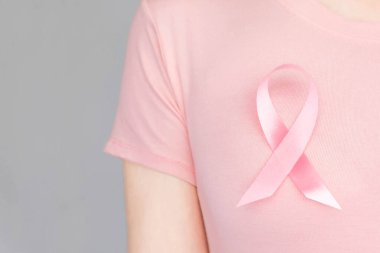 Dünya Göğüs Kanseri Günü Konsepti, sağlık hizmetleri - kadın beyaz tişört, göğüs kanseri farkındalığı için pembe kurdele, sembolik yay rengi kadın meme tümörü hastalığına yakalanmış insanlar üzerinde farkındalık yaratıyor