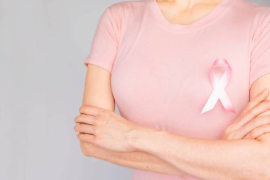 Dünya Göğüs Kanseri Günü Konsepti, sağlık hizmetleri - kadın beyaz tişört, göğüs kanseri farkındalığı için pembe kurdele, sembolik yay rengi kadın meme tümörü hastalığına yakalanmış insanlar üzerinde farkındalık yaratıyor