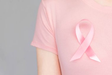 Dünya Göğüs Kanseri Günü Konsepti, sağlık hizmetleri - kadın beyaz tişört, göğüs kanseri farkındalığı için pembe kurdele, sembolik yay rengi kadın meme tümörü hastalığına yakalanmış insanlar üzerinde farkındalık yaratıyor