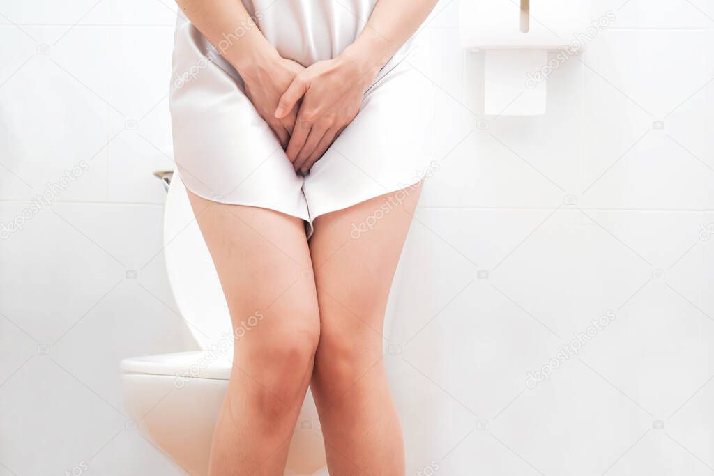 Women wearing white sleepwear,standing in the toilet, Hands holding crotch bottom, Sit on the toilet