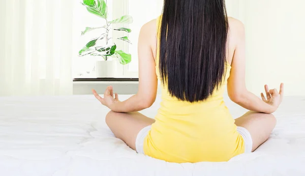 Sarı Fanila Giyen Beyaz Yatakta Otururken Yoga Yapan Asyalı Genç — Stok fotoğraf