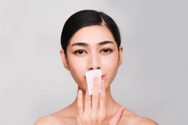 Güzellik konsepti, temiz ve parlak ciltli genç Asyalı bir kadın yüzü temizlemek için pamuk çubuğu, toner şişesi, cilt temizleyici ürünler.