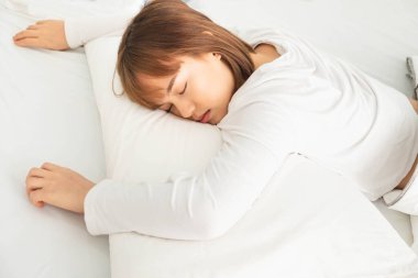 Kısa saçlı güzel Asyalı kadınlar, beyaz gömlekler giyerler, beyaz bir yatakta uyurlar, rahatlarlar ve iyi uyurlar, sabahları yatakta rahat ederler, sabahları yatakta tatlı rüyalar görürler.