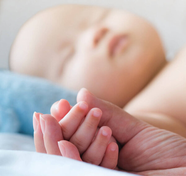 happy and enjoy Portrait of a newborn Asian baby boy on the bed, a dummy in his mouth, Charming
