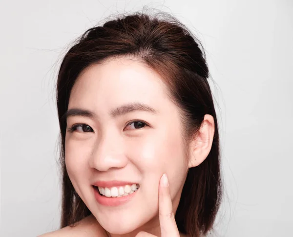 きれいな肌と明るい肌を持つ若い美しいアジアの女性 化粧品の美しさのコンセプト 頬に手のタッチ 灰色の背景に隔離された笑顔とフレンドリーな顔 — ストック写真