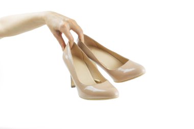 Beyaz arka planda yüksek topuklu ayakkabı tutuyor.