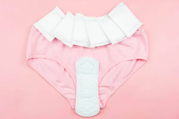 Üst görünüm beyaz hijyenik peçete ve pembe arka planda pembe altlıklar.