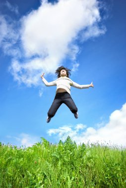 Genç kadın içine alan mavi gökyüzü atlama