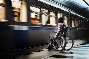 Metro istasyonunda tekerlekli sandalyedeki kadın