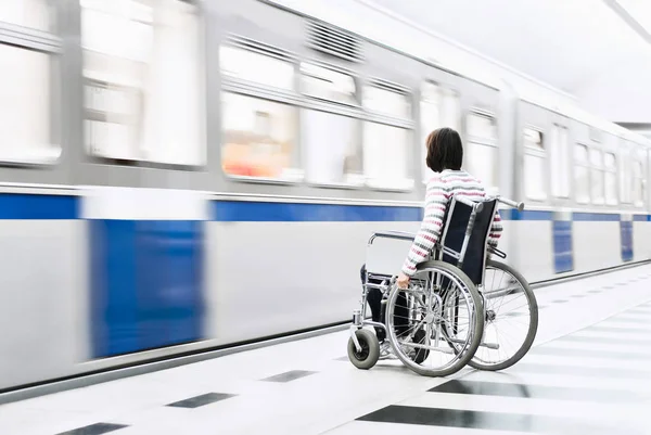 Mujer en silla de ruedas en la estación de metro —  Fotos de Stock
