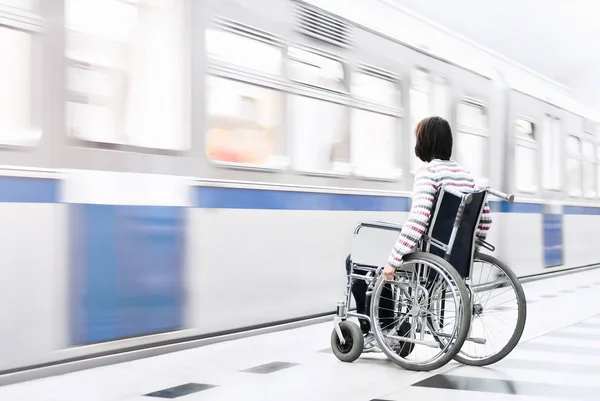 Žena na vozíčku u stanice metra — Stock fotografie