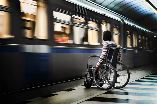 Mujer en silla de ruedas en la estación de metro —  Fotos de Stock