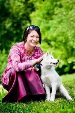 Bir köpek yavrusu husky ile gülümseyen genç kadın