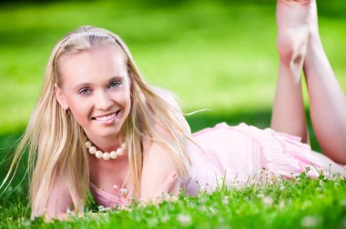 Güzel sarışın çim üzerinde yalan