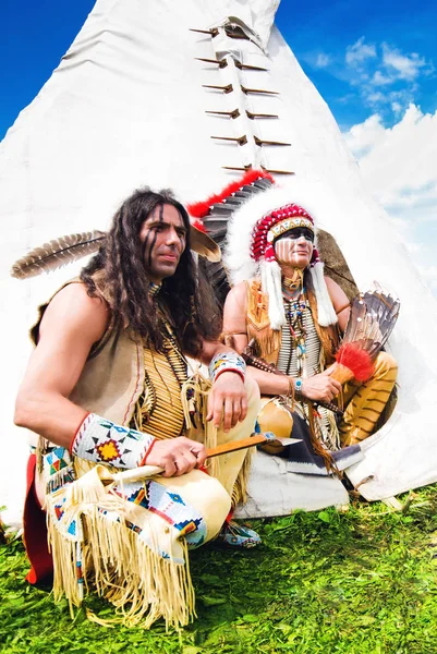 Two american indian sits beside wigwam — Stock Photo, Image