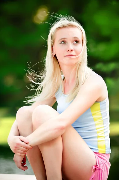 Çok gülümseyen sarışın parkta oturan