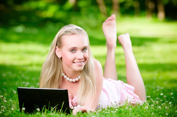 Piękna blondynka na trawie z laptopa Obrazek Stockowy