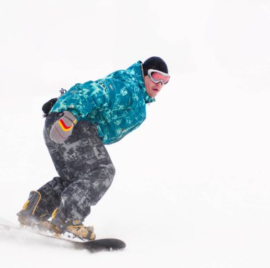 Tahta üzerinde mavi ceketli genç snowboarder