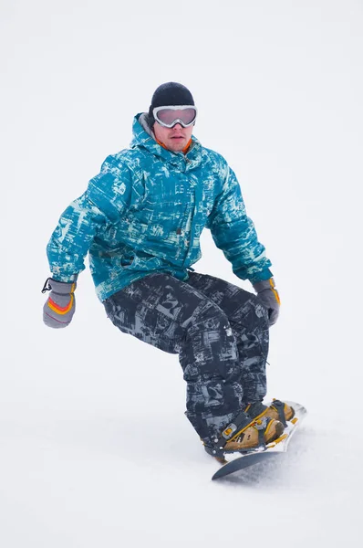 Tahta üzerinde mavi ceketli genç snowboarder — Stok fotoğraf