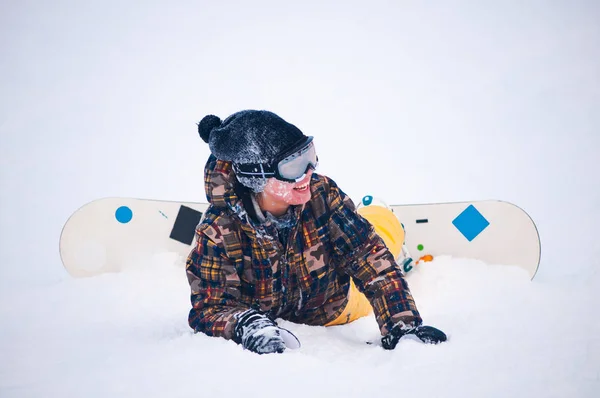 Young girl snowboarder in yellow pants on the board — Stock Photo, Image