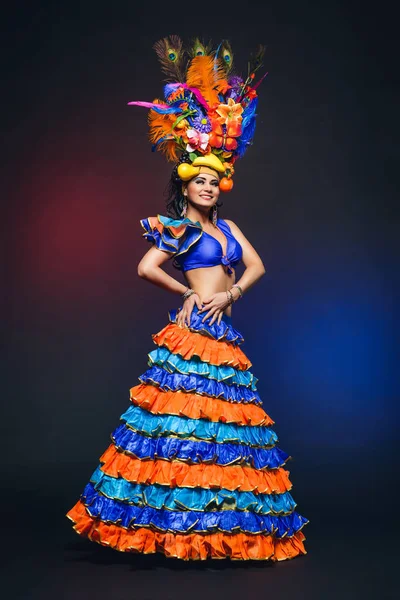 Sevimli genç kız karanlık arka parlak renkli karnaval kılık — Stok fotoğraf