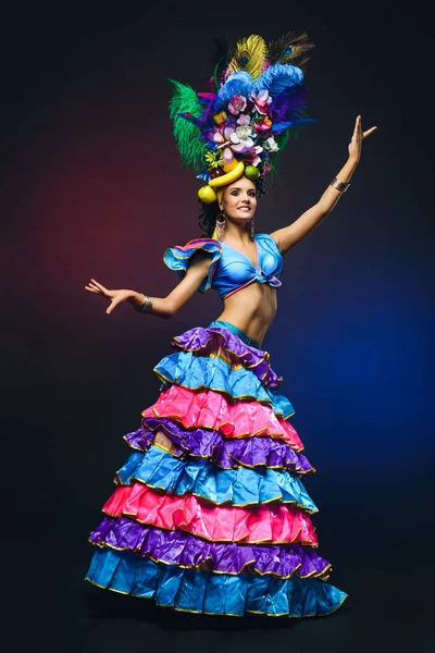 Linda chica joven en traje de carnaval de colores brillantes en la espalda oscura — Foto de Stock